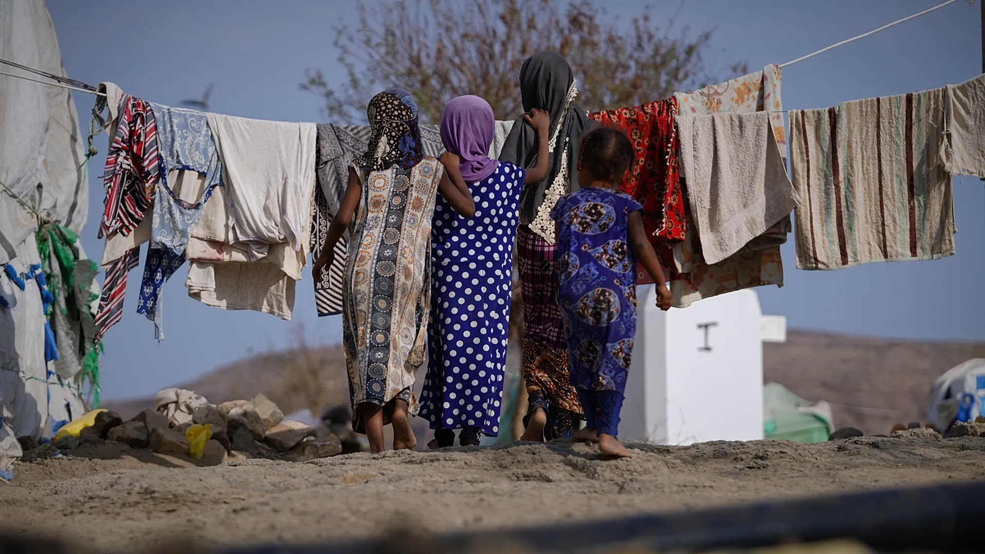 Children and families walking among tents at a displacement site in Yemen.