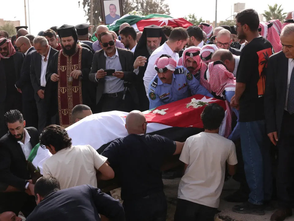 Editorial photograph illustrating Thousands mourn Jordan church attack victims as security response widens