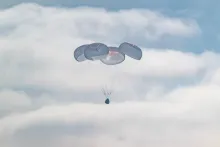 Crew Dragon Freedom descends beneath parachutes into the Pacific Ocean after NASA’s Crew-12 mission.