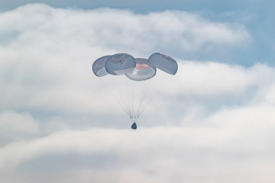 Crew Dragon Freedom descends beneath parachutes into the Pacific Ocean after NASA’s Crew-12 mission.